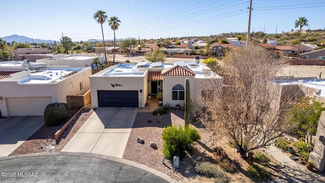 view of front of house featuring concrete driveway, an attached garage, a residential view, and stucco siding