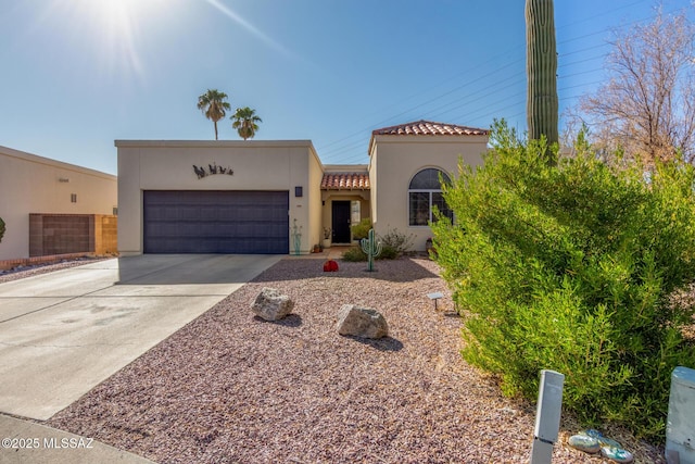 view of front facade featuring a garage, a tiled roof, driveway, and stucco siding