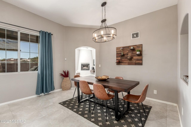 dining area featuring a notable chandelier, visible vents, arched walkways, and baseboards