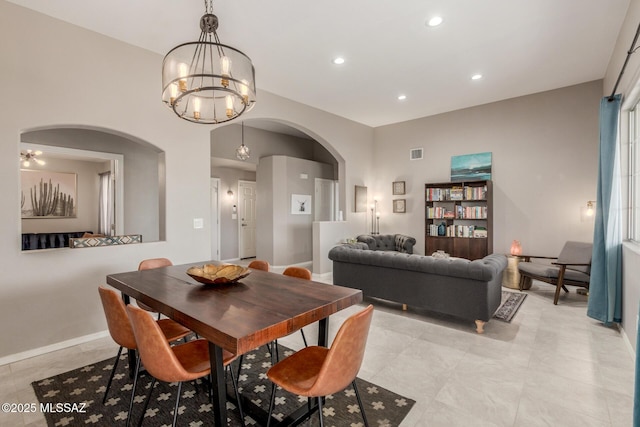 dining space with arched walkways, recessed lighting, visible vents, an inviting chandelier, and baseboards