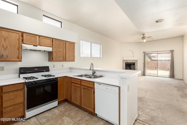 kitchen featuring under cabinet range hood, a peninsula, a sink, dishwasher, and gas range oven