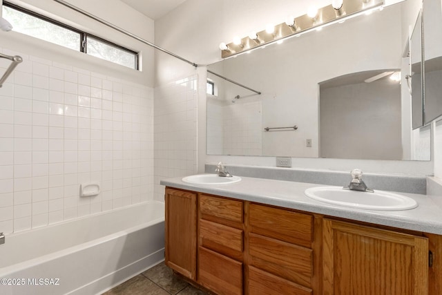 full bath with double vanity, tile patterned flooring, shower / tub combination, and a sink