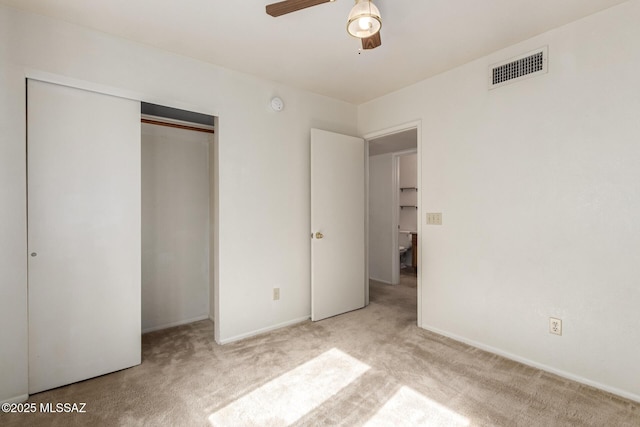 unfurnished bedroom featuring carpet floors, a closet, visible vents, ceiling fan, and baseboards