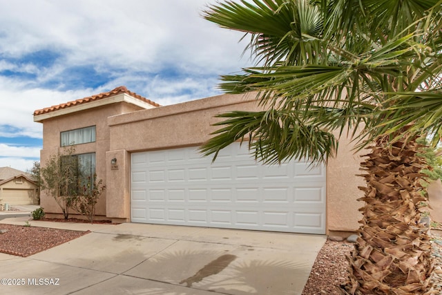 mediterranean / spanish-style house with driveway, a tiled roof, a garage, and stucco siding