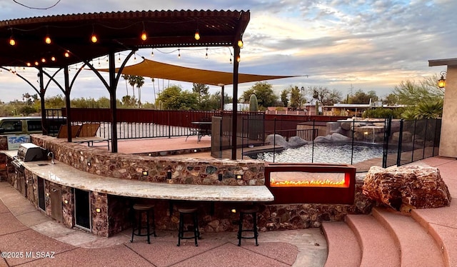 view of home's community featuring fence, an outdoor kitchen, a pergola, and a patio