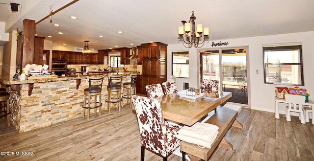 dining space featuring light wood finished floors, recessed lighting, visible vents, a chandelier, and baseboards