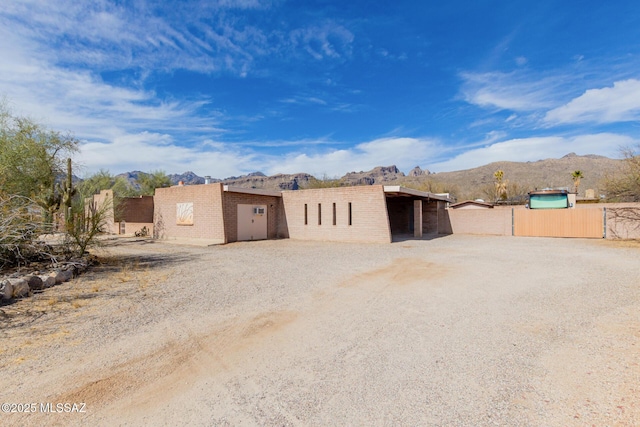 view of outdoor structure with an outbuilding, a mountain view, and fence