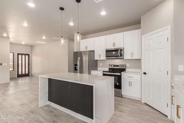 kitchen featuring light wood finished floors, a kitchen island, appliances with stainless steel finishes, and white cabinets