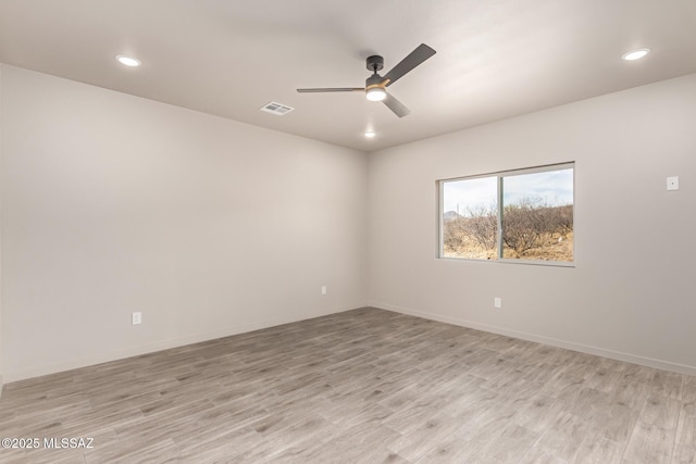 unfurnished room with ceiling fan, light wood-type flooring, visible vents, and baseboards