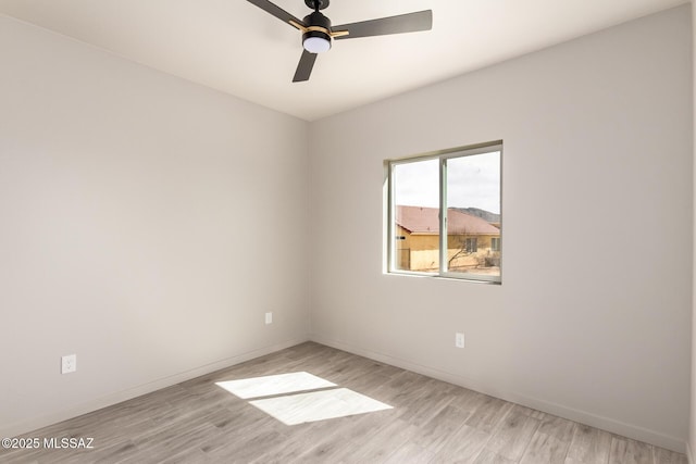 empty room with light wood finished floors, ceiling fan, and baseboards