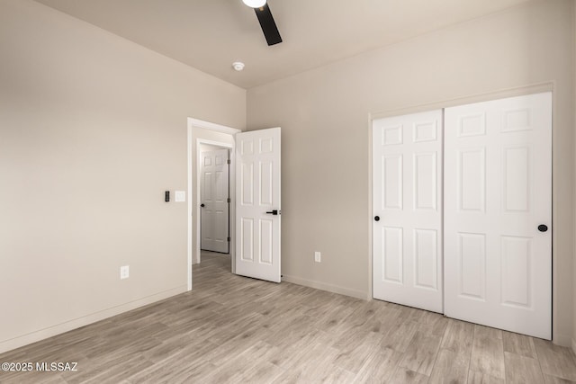 unfurnished bedroom with baseboards, ceiling fan, a closet, and light wood-style floors