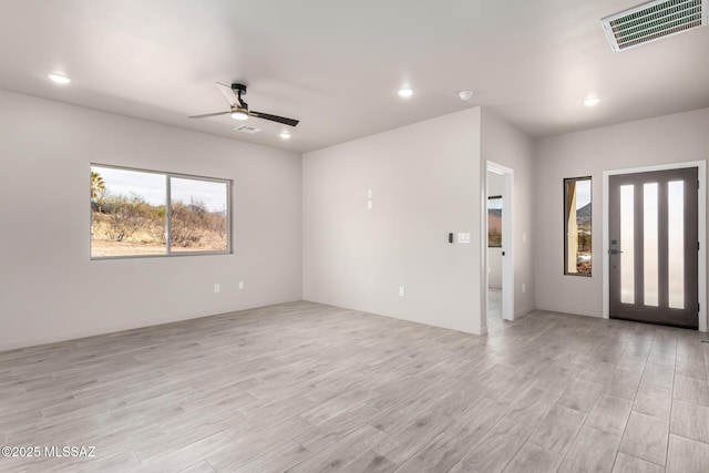 interior space with light wood finished floors, visible vents, a wealth of natural light, and recessed lighting