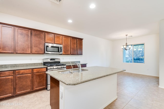 1091 E Empire Canyon Ln, Sahuarita, AZ 85629 - kitchen with light stone counters, stainless steel appliances, a sink, an island with sink, and pendant lighting