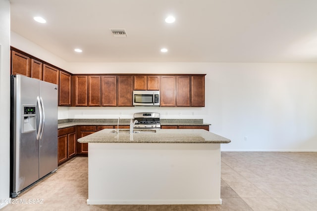 1091 E Empire Canyon Ln, Sahuarita, AZ 85629 - kitchen with stainless steel appliances, recessed lighting, visible vents, a kitchen island with sink, and light stone countertops