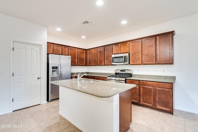 1091 E Empire Canyon Ln, Sahuarita, AZ 85629 - kitchen with light stone counters, stainless steel appliances, visible vents, a kitchen island with sink, and a sink