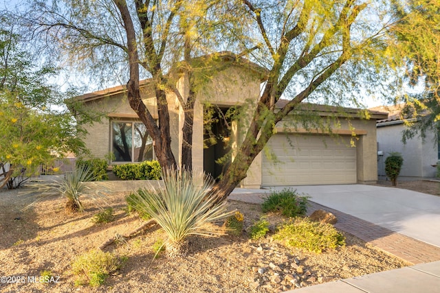 view of front facade with a garage, concrete driveway, and stucco siding