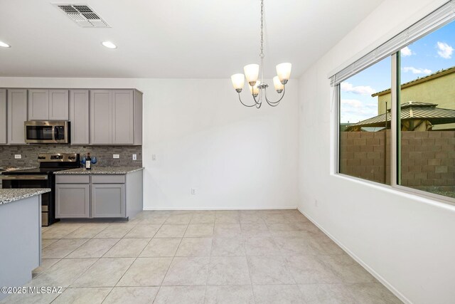 kitchen with tasteful backsplash, appliances with stainless steel finishes, visible vents, and gray cabinetry