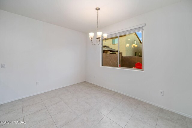 unfurnished room with baseboards and a notable chandelier