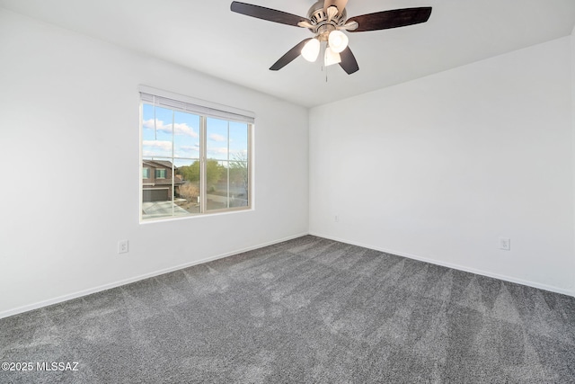 spare room featuring dark carpet, a ceiling fan, and baseboards