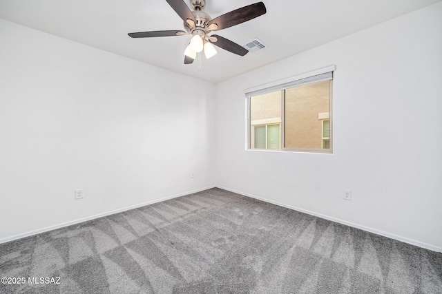 empty room with carpet, visible vents, ceiling fan, and baseboards