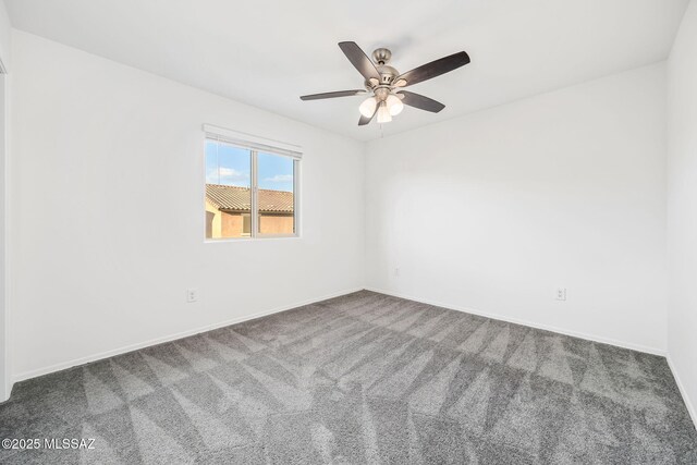 carpeted spare room with ceiling fan and baseboards