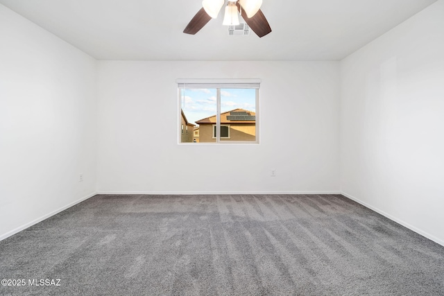 unfurnished room with carpet floors, visible vents, ceiling fan, and baseboards