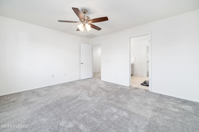 unfurnished bedroom featuring baseboards, connected bathroom, visible vents, and light colored carpet