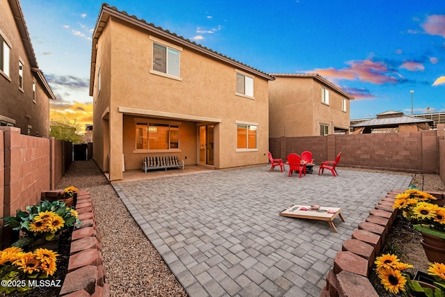 rear view of property featuring a fenced backyard, a patio, and stucco siding