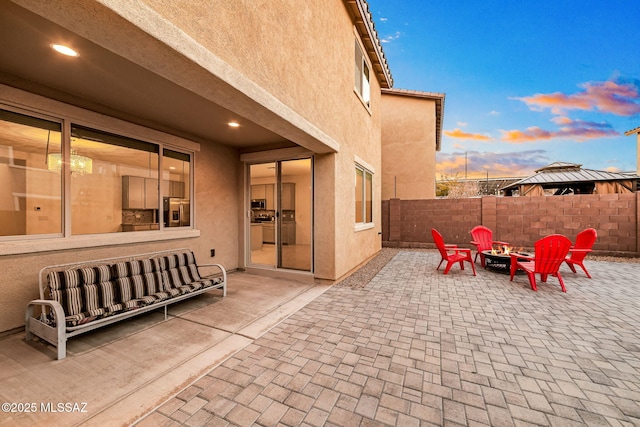 view of patio featuring a fire pit and fence