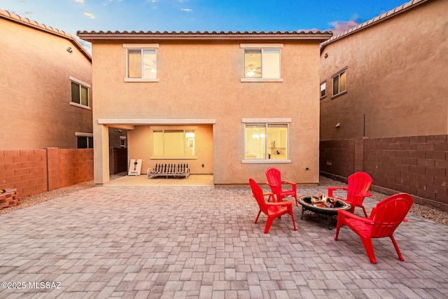 back of house with an outdoor fire pit, fence, a patio, and stucco siding