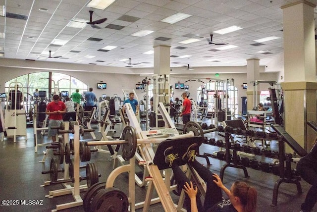 exercise room with a paneled ceiling and a ceiling fan