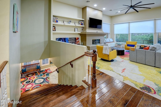 interior space featuring a glass covered fireplace, hardwood / wood-style flooring, recessed lighting, and visible vents