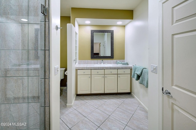 full bath with vanity, tile patterned floors, toilet, and a tile shower