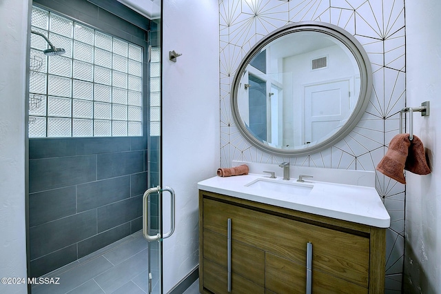 bathroom featuring visible vents, a stall shower, and vanity