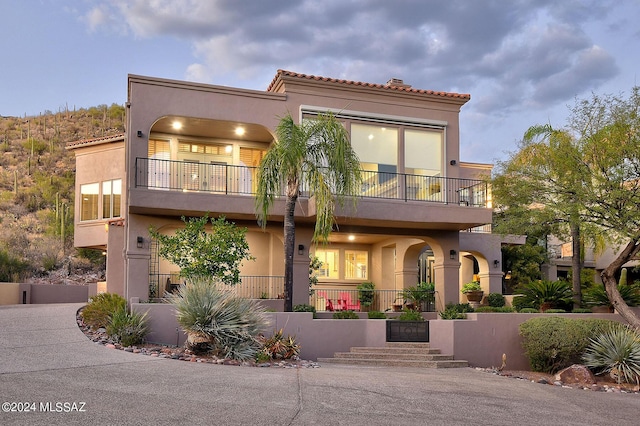 mediterranean / spanish-style house featuring a balcony and stucco siding