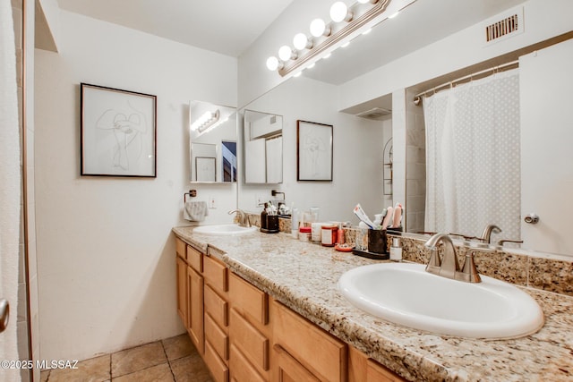 bathroom with curtained shower, tile patterned flooring, a sink, and visible vents