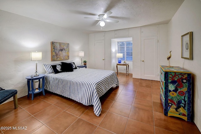 bedroom with tile patterned flooring, ceiling fan, and a textured ceiling