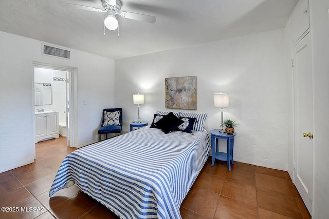 bedroom featuring ceiling fan, tile patterned floors, visible vents, and connected bathroom