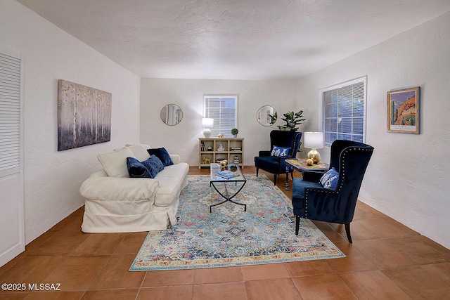 living room with tile patterned floors, a textured ceiling, and a textured wall