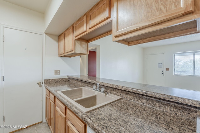 kitchen featuring light tile patterned flooring and a sink