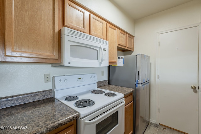 kitchen featuring dark countertops and white appliances