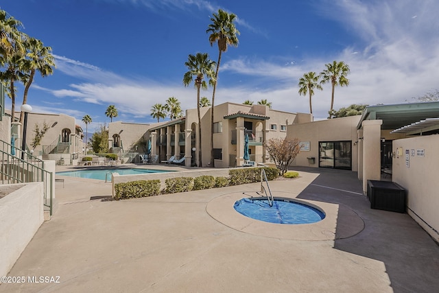 pool with a residential view and a patio