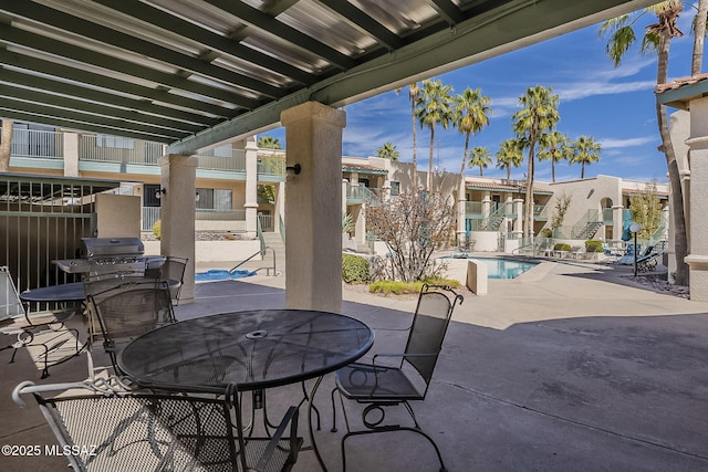 view of patio / terrace featuring a community pool, a residential view, and outdoor dining space