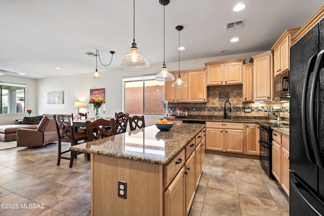 kitchen featuring light brown cabinets, visible vents, a sink, and black appliances