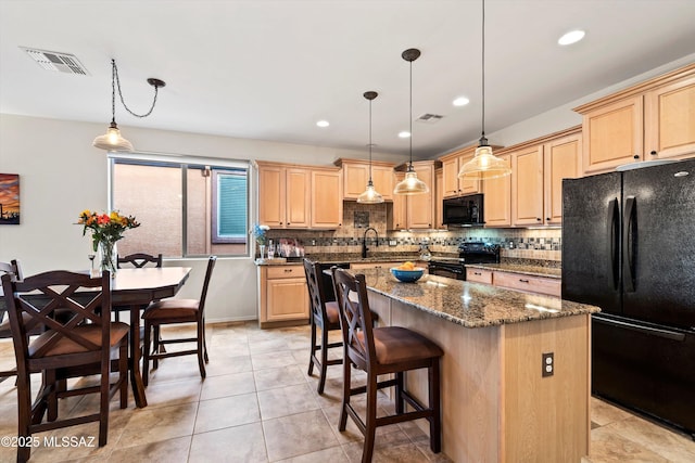 kitchen featuring black appliances, visible vents, and light brown cabinetry