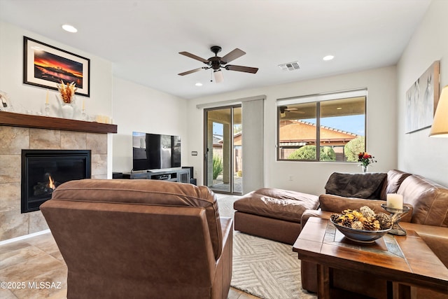 living area featuring a tile fireplace, visible vents, and recessed lighting