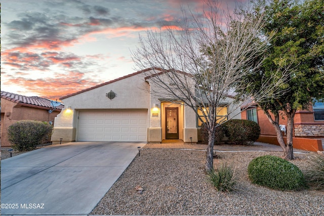 view of front facade with driveway, an attached garage, and stucco siding