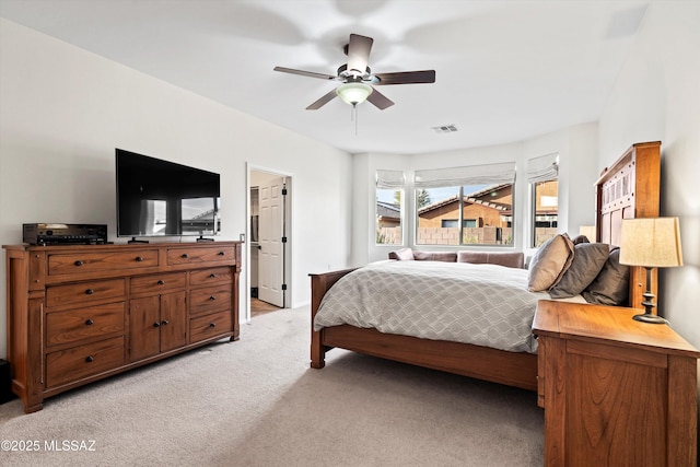 bedroom featuring ceiling fan, visible vents, and light colored carpet