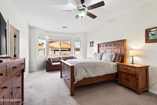 bedroom featuring baseboards, visible vents, and light colored carpet