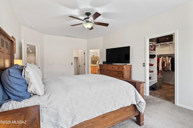 bedroom featuring visible vents, a ceiling fan, a walk in closet, carpet floors, and a closet